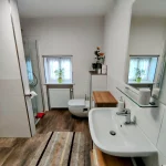 Helles Badezimmer mit Waschmaschine und Möbeln.