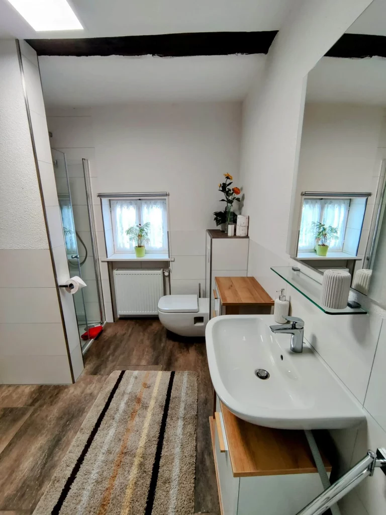 Helles Badezimmer mit Waschmaschine und Möbeln.