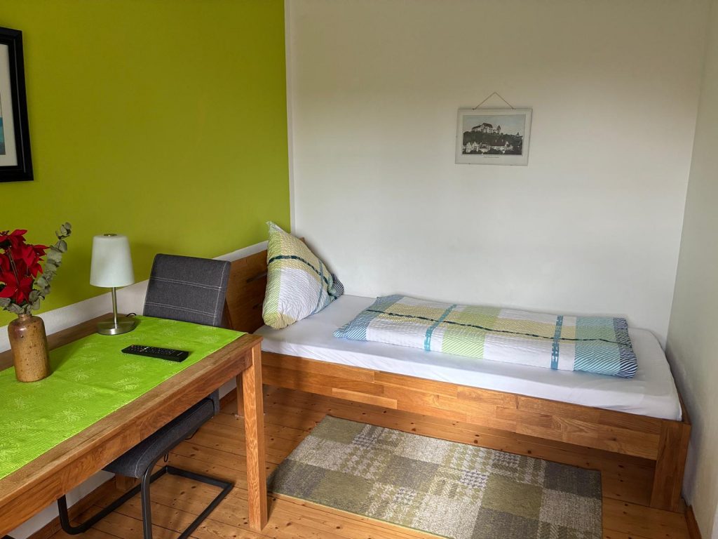 Helles Zimmer mit Bett und Tisch