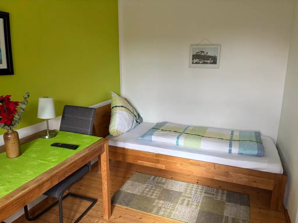 Helles Zimmer mit Bett und Tisch