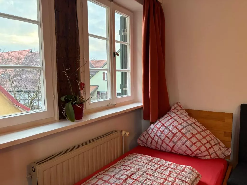 Gemütliches Zimmer mit Fenster und Bett